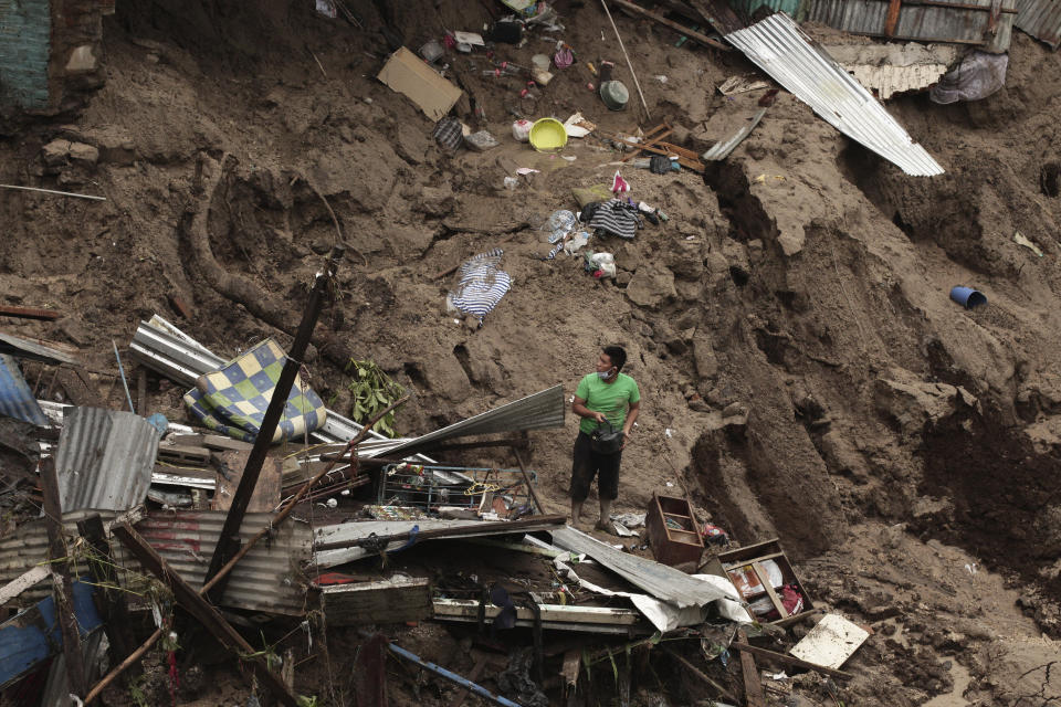 A man seeks to salvage some of his belongings from what used to be his home, destroyed by the waters of the Acelhuate River, in the New Israel Community of San Salvador, El Salvador, Sunday, May 31, 2020. According to the Ministry of the Interior at least seven people died across the country after two days of heavy rains. (AP Photo/Salvador Melendez)