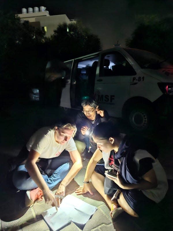 Emily Callahan, an American nurse with Doctors without Borders, sheltered in Khan Younis before evacuating. Here, she and colleagues work on a map to track her colleagues and the cars in their evacuation convoy.