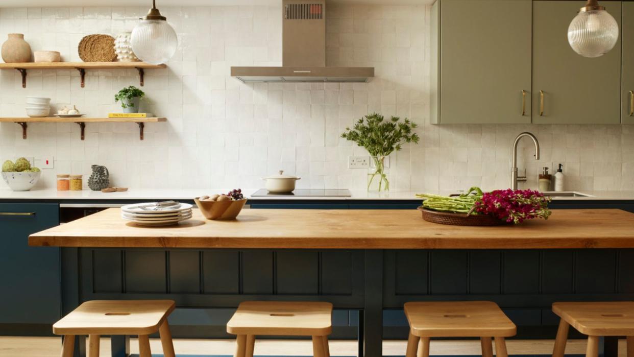  A kitchen with blue cabinets and a butcher block island 