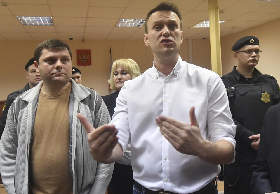 Russian opposition leader Alexei Navalny, right, and his former colleague Pyotr Ofitserov, left, speak to journalists in the court in Kirov, Russia, Wednesday, Feb. 8, 2017. A Russian court on Wednesday found opposition leader Alexei Navalny guilty in the retrial of a 2013 fraud case, which disqualifies him as a candidate for president next year. However, an associate said Navalny will carry on with the campaign he announced in December. (AP Photo/Sergei Bonurin)