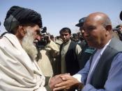 An Afghan government delegate (R) shakes hands with an elder at a mosque in Alokozai village of Pajwayi district in Kandahar province on March 13, 2012. Gunmen on Tuesday attacked an Afghan memorial service in Alokozai for 16 villagers killed by a US soldier, shooting dead a member of the Afghan military and wounding a policeman in a hail of gunfire