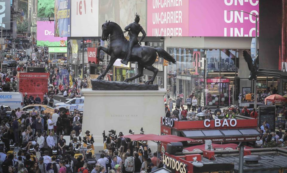 A bronze sculpture, "Rumors of War," by artist Kehinde Wiley, appears in Times Square at an unveiling on Friday Sept. 27, 2019, in New York. The work, depicting of a young African American in urban streetwear sitting astride a galloping horse, will be exhibited through December 1. (AP Photo/Bebeto Matthews)