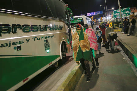 Venezuelan migrants walk next to the tourist transport buses at the Rumichaca International Bridge, Ecuador August 17, 2018. Picture taken August 17, 2018. REUTERS/Luisa Gonzalez