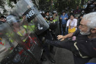 <p>An anti-government protester kicks at riot police blocking a march of elders against President Nicolas Maduro in Caracas, Venezuela, May 12, 2017. The protest billed as the “March of the Grandparents” comes on the heels of six weeks of political unrest that have left some three dozens killed. (Photo: Fernando Llano/AP) </p>