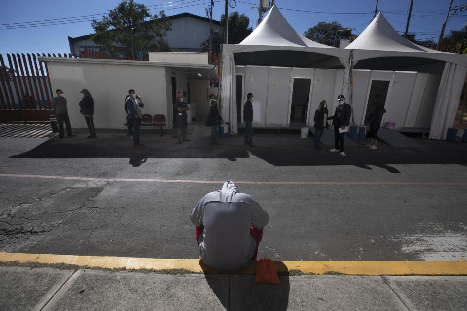 A young man waits to be tested for COVID-19 outside the Ajusco Medio General Hospital in Mexico City, Thursday, Nov. 19, 2020. (AP Photo/Marco Ugarte)