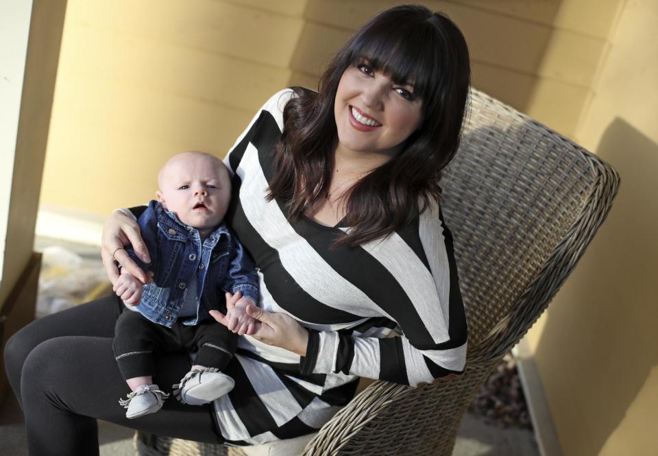 Rachel Potter holds her son, Jude, Tuesday, Jan. 31, 2017, at their home in Nashville, Tenn. Potter, a Nashville-based singer who has toured the country as part of the cast of the hit musical "Wicked" as well as performing gigs with her country music band Steel Union, said she couldn't afford insurance before the Affordable Care Act. From a return to higher premiums based on female gender, to gaps in coverage for breast pumps used by nursing mothers, President Donald Trump's vow to repeal his predecessor's health care law is raising concerns about the impact on women's health. (AP Photo/Mark Humphrey)