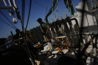 Crew work together to prepare two less damaged shrimp boats to get back out on the water quickly, after most of the fleet at Erickson & Jensen Seafood was grounded or heavily damaged by the passage of Hurricane Ian, on San Carlos Island in Fort Myers Beach, Fla., Friday, Oct. 7, 2022. (AP Photo/Rebecca Blackwell)