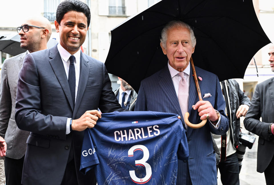 Paris Saint Germain's president Nasser Al-Khelaifi offers Britain's King Charles III a PSG jersey, Thursday, Sept. 21, 2023 in Saint-Denis, outside Paris. On the second day of his state visit to France, King Charles met with sports groups in the northern suburbs of Paris and was scheduled to pay a visit to fire-damaged Notre-Dame cathedral. (Bertrand Guay, Pool via AP)
