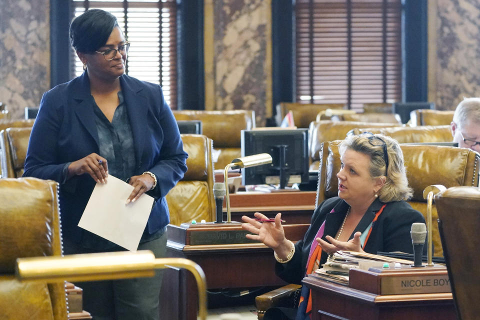 Sen. Angela Turner Ford, D-West Point, left, listens to Sen. Nicole Boyd, R-Oxford, discuss legislation, in the Senate Chamber, Monday, March 28, 2022, at the Mississippi Capitol in Jackson. (AP Photo/Rogelio V. Solis)