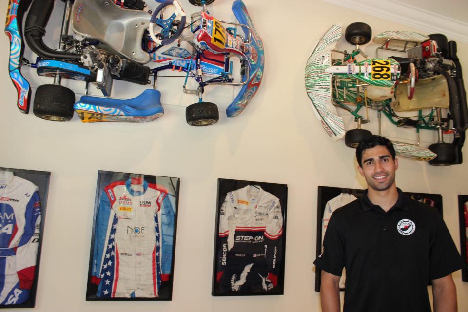 Race car driver Juan Manuel Correa with some of his racing artifacts in his family's home in South Miami-Dade County. The dark blue racing suit on his immediate right is what he was wearing during his 2019 crash in Belgium that nearly cost him his right leg. His friend,  Anthoine Hubert, died in the four-car accident.