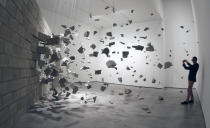 A visitor takes pictures of an installation representing an exploding wall by Cuban artists Dagoberto Rodriguez and Marco Castillo during an exhibit at Es Baluard museum in Palma de Mallorca, on the Spanish Balearic islands, October 17, 2011. REUTERS/Enrique Calvo