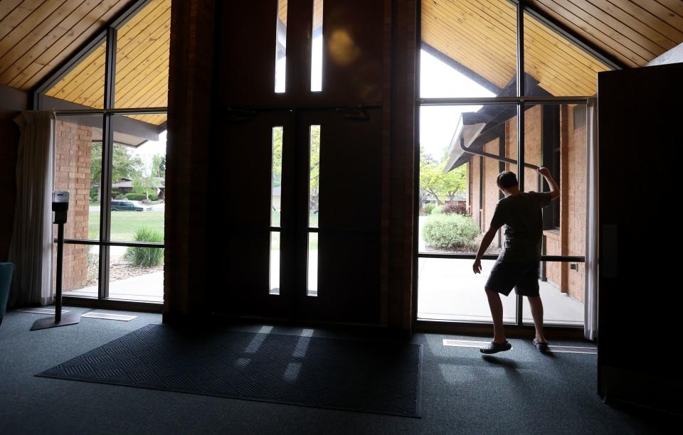 Connor Campbell, 16, knocks on windows and runs around an empty church near his home in Provo on Sunday, May 28, 2023. Connor is autistic, nonverbal and has epilepsy. He lives at the Utah State Developmental Center in American Fork but comes home on Sundays. | Kristin Murphy, Deseret News