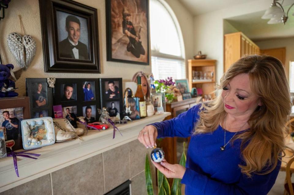 Francine Turner holds a Christmas ornament with snowmen made by her son Tyler’s fingerprints while remembering him on his birthday Feb. 25, 2023, in Los Banos. Tyler died while skydiving near Lodi. 