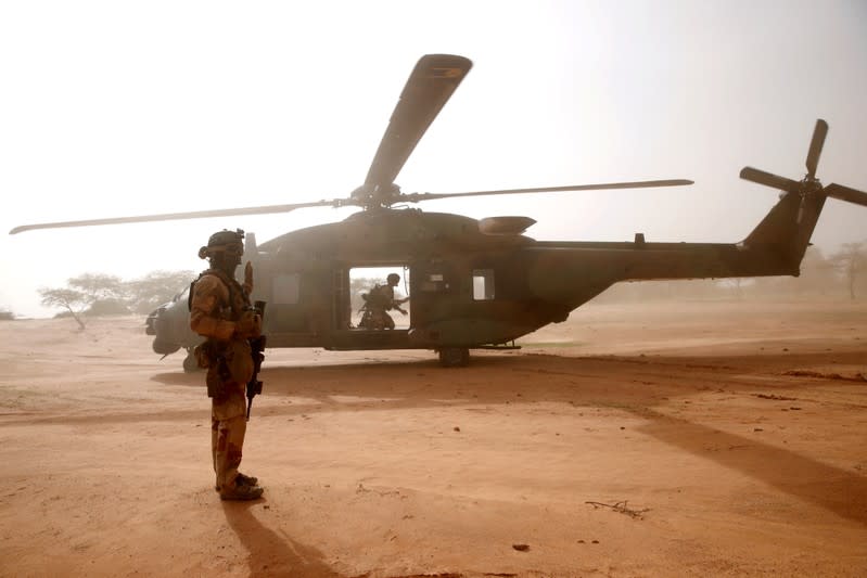 FILE PHOTO: A French soldier stands guards in front of an NH90 Caiman military helicopter during Operation Barkhane in Ndaki