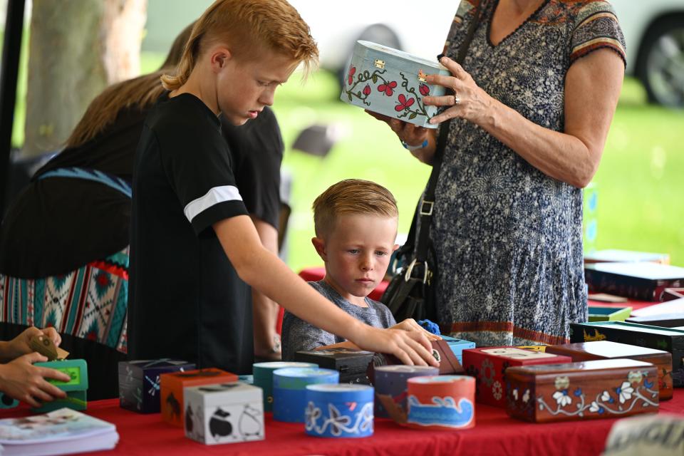 Jackson Kroll and his little brother Cooper Kroll look at items for sale at Utah Native Market Days at Thanksgiving Point in Lehi on Friday, Aug. 11, 2023. All proceeds are going to native student scholarships. There was hoop dancing, food and crafts. | Scott G Winterton, Deseret News