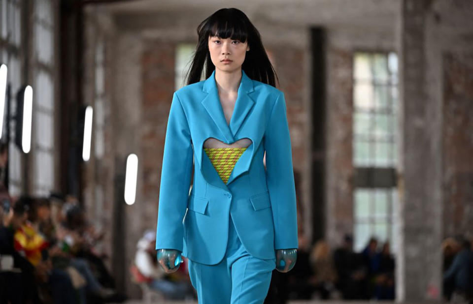 A Botter model walks the runway with condom gloves at Paris Fashion Week