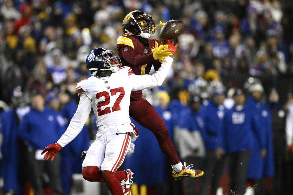 Washington Commanders wide receiver Jahan Dotson (1) catches a pass over New York Giants cornerback Jason Pinnock (27) during the second half of an NFL football game, Sunday, Dec. 18, 2022, in Landover, Md. (AP Photo/Nick Wass)