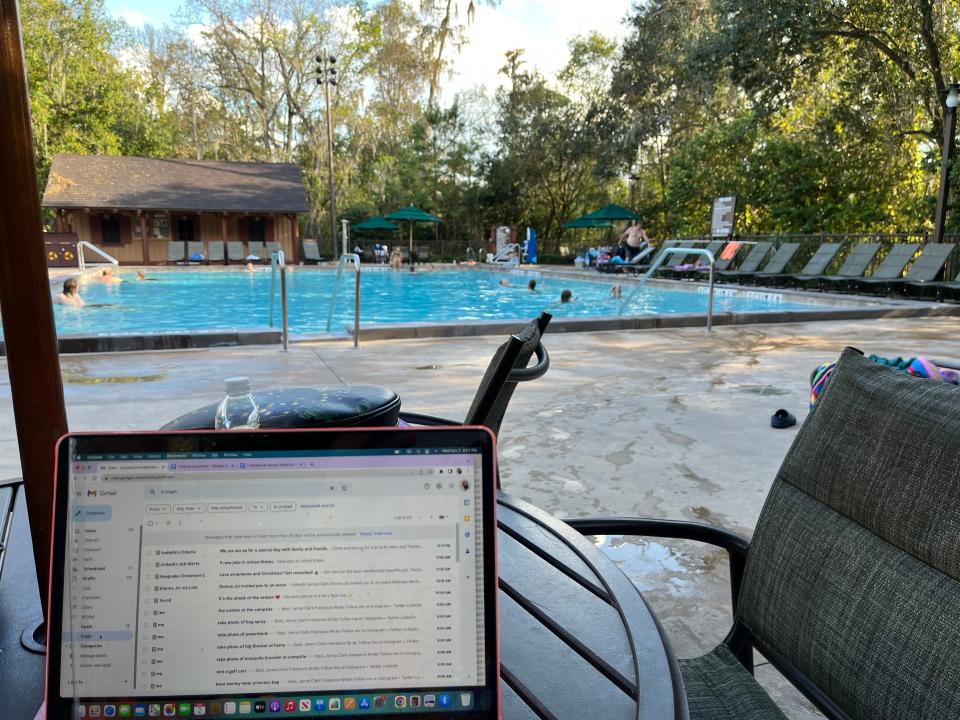 the writer working on her laptop near the pool