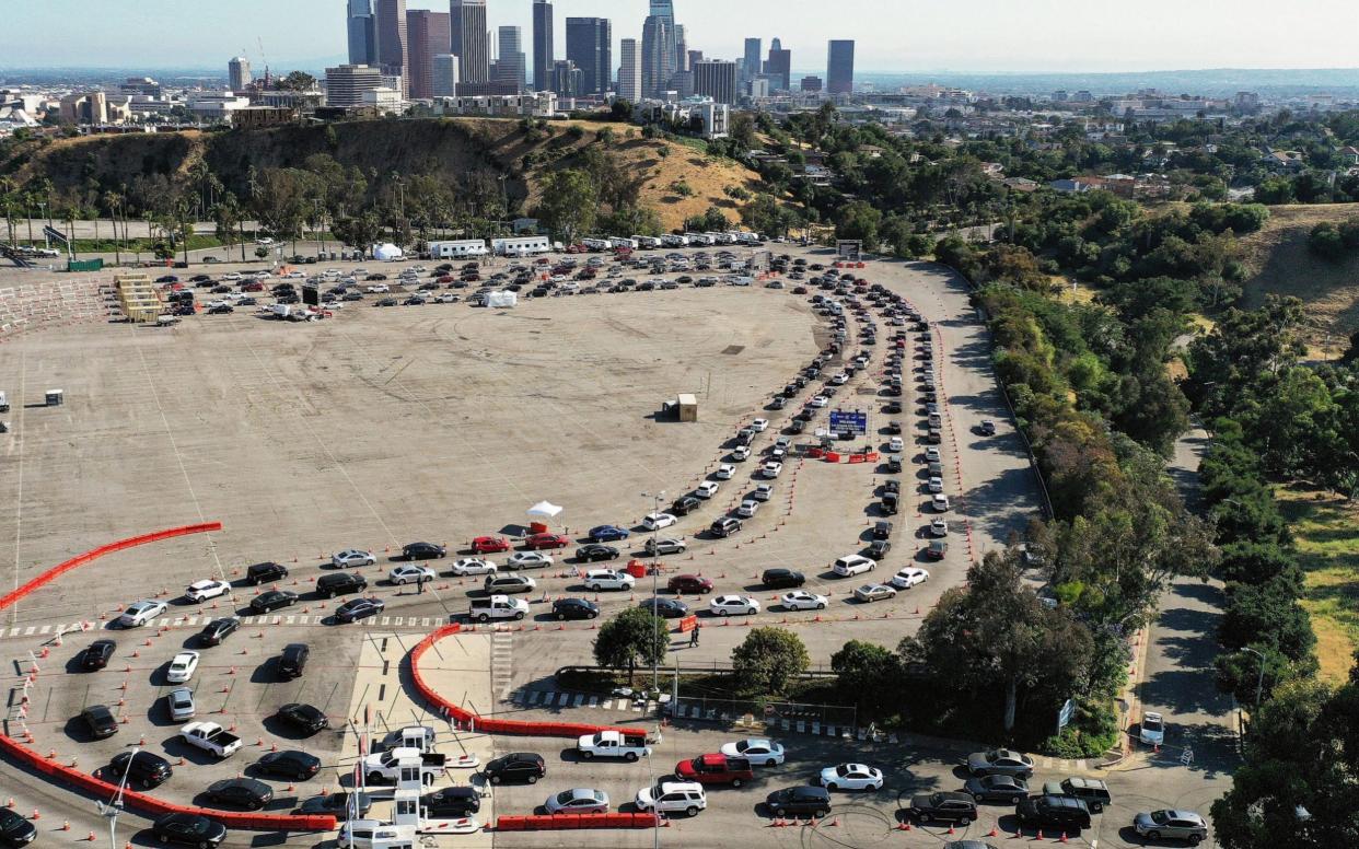 An aerial view of people in cars lined up to be tested for Covid-19 in a parking lot at Dodger Stadium in Los Angeles, California - Mario Tama/Getty Images North America