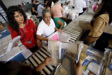 Employees pack electoral material and ballots in boxes, which will be distributed throughout the country, at a warehouse in Guatemala City October 21, 2015. REUTERS/Jorge Dan Lopez