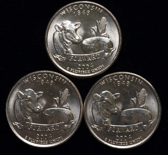 Wisconsin quarters are displayed at Old Pueblo Coin Exchange. Inc, in Tucson on Monday, Jan. 10, 2005. The coin at top is correct with no defects. The two coins on the bottom are variations with unusual markings on the back resembling extra corn leaves. The markings are of two distinct styles. The one on the left carries the 