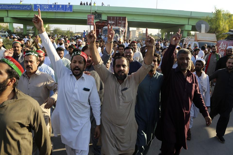 Supporters of former Prime Minister Imran Khan's party chant slogans while they block a highway during a protest to condemn the election commission's decision, in Islamabad, Pakistan, Friday, Oct. 21, 2022. Pakistan’s elections commission on Friday disqualified former Prime Minister Imran Khan from holding public office for five years, after finding he had unlawfully sold state gifts and concealed assets as premier, officials said. (AP Photo)