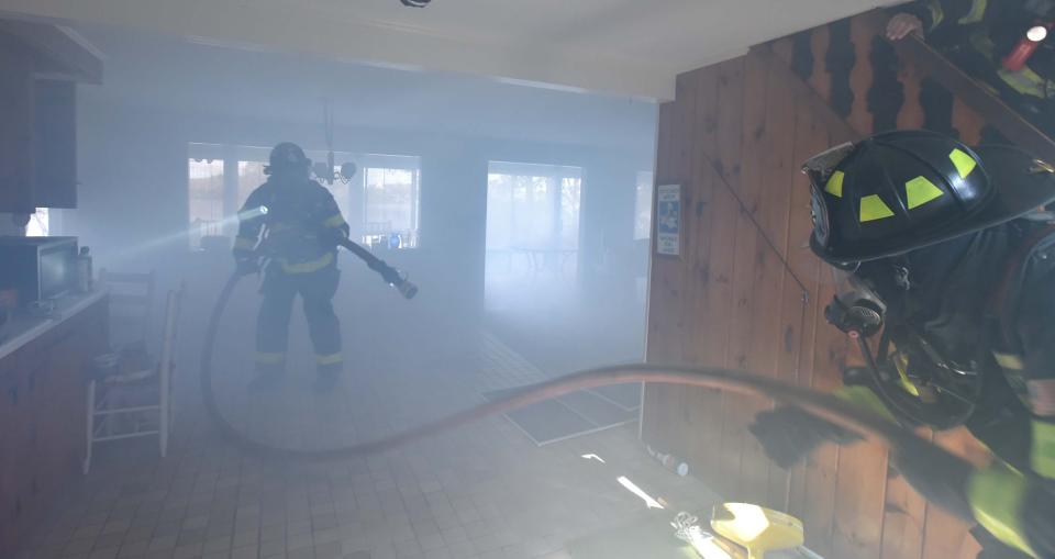 Crews advance a line into the first floor before moving it to the second floor during a Wednesday morning training drill for firefighters of the Centerville-Osterville-Marstons Mills department at a home on Point of Pines Road in Centerville that will be demolished. The smoke was generated from a smoke machine.