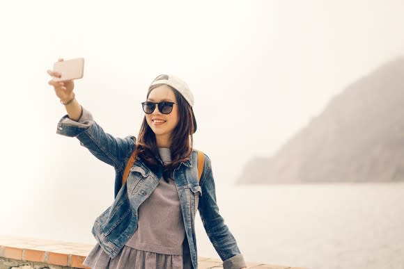 A young woman takes a selfie.