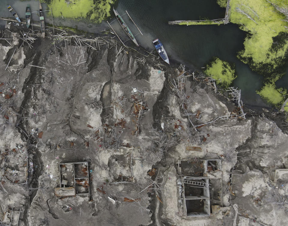 The remains of the Alas-as elementary school are seen in the middle of patterns of erosion on volcanic ash deposits at the Taal volcano almost a year after it erupted, on Sunday, Jan. 10, 2021 in Batangas province, Philippines. A popular tourist destination just south of Manila because of its picturesque setting in the middle of a lake, Taal erupted on Jan. 12, 2020. The eruption displaced thousands of villagers living near the area and delivered an early crisis this year for one of the world's most disaster-prone nations a couple of months before the COVID-19 pandemic broke in the country. (AP Photo/Aaron Favila)