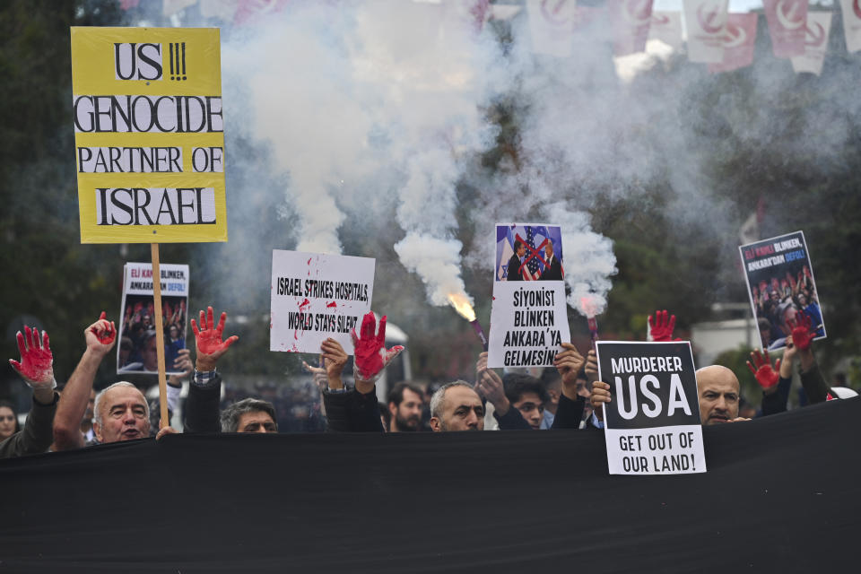 People hold up boards during a pro Palestinian protest outside the Turkish Foreign Affairs Ministry in Ankara, Turkey, Monday, Nov. 6, 2023. Dozens of protesters have congregated in front of Turkey's Foreign Ministry where the Turkish and U.S. top diplomats are holding talks, accusing the United States of complicity in the deaths of Palestinian civilians in Gaza. Board in centre reads in Turkish: "Zionist Blinken should not come to Ankara". (AP Photo/Ali Unal)