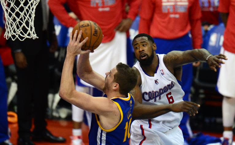 David Lee of the Golden State Warriors (L) scores under pressure from DeAndre Jordan of the Los Angeles Clippers in Los Angeles, California on April 19, 2014