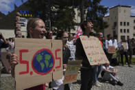 Climate activists perform with posters during a climate protest alongside the World Economic Forum in Davos, Switzerland, Thursday, May 26, 2022. The annual meeting of the World Economic Forum is taking place in Davos from May 22 until May 26, 2022. (AP Photo/Evgeniy Maloletka)