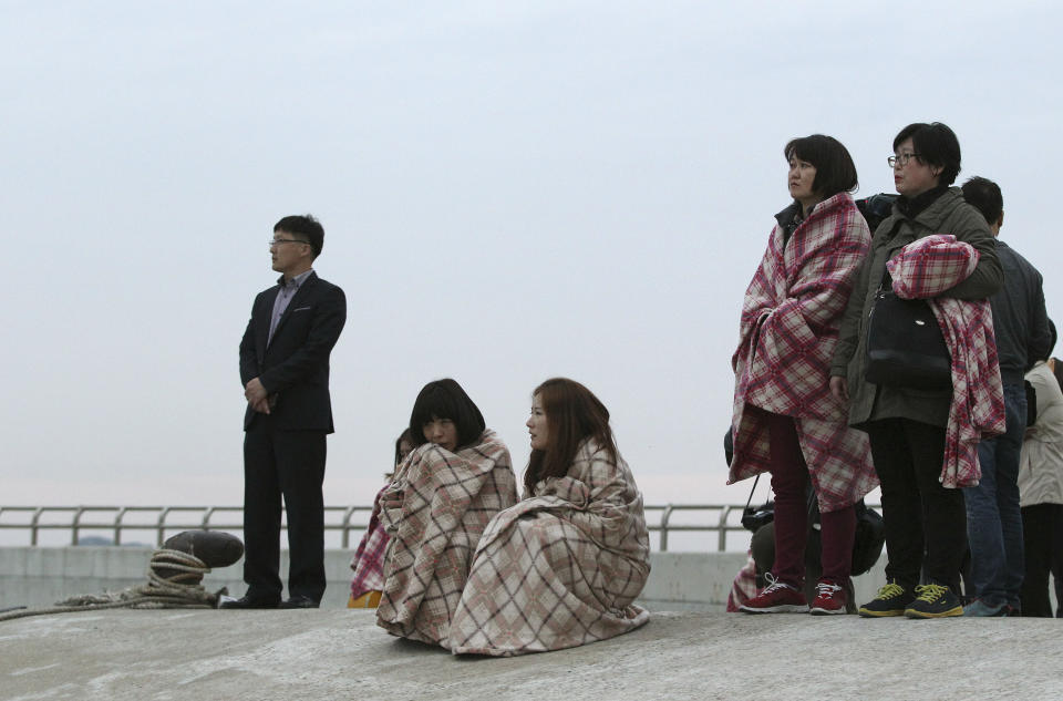 Relatives wait for their missing loved ones at a port in Jindo, South Korea, Wednesday, April 16, 2014. A ferry carrying 459 people, mostly high school students on an overnight trip to a tourist island, sank off South Korea's southern coast on Wednesday, leaving nearly 300 people missing despite a frantic, hours-long rescue by dozens of ships and helicopters. (AP Photo/Ahn Young-joon)