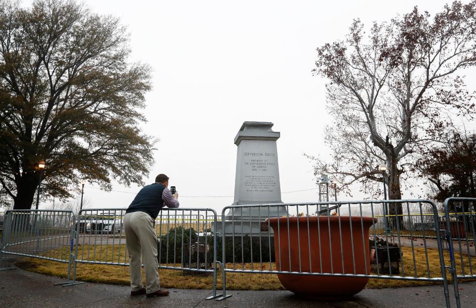 Memphian Brett Schutt takes a picture of the removed statue of Confederate President Jefferson Davis in Fourth Bluff Park. The city of Memphis sold two public parks containing Confederate monuments to a nonprofit in a massive, months-in-the-planning operation to take the statues down overnight.