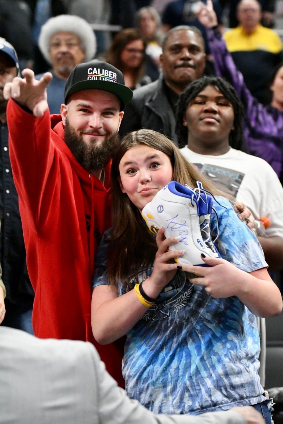 Pacers fans pose with Lance Stephenson's autographed sneaker after Indiana hosted Philadelphia at Gainbridge Fieldhouse in Indianapolis on April 5, 2022.