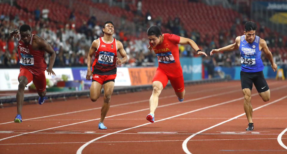 China's Su Bingtian, second right, crosses the finish line to win the men's 100m final during the athletics competition at the 18th Asian Games in Jakarta, Indonesia, Sunday, Aug. 26, 2018. (AP Photo/Bernat Armangue)