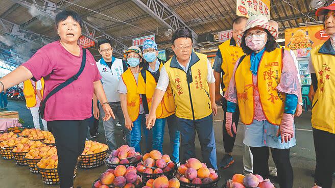 參選下屆台南市第二選區立委的無黨議員陳昆和（右前三），21日前進玉井果菜市場採買芒果，解決芒果過剩問題。（程炳璋攝）