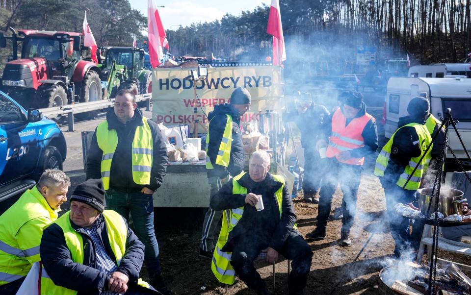 Farmers camp with their tractors to block a road near the German border in Poland