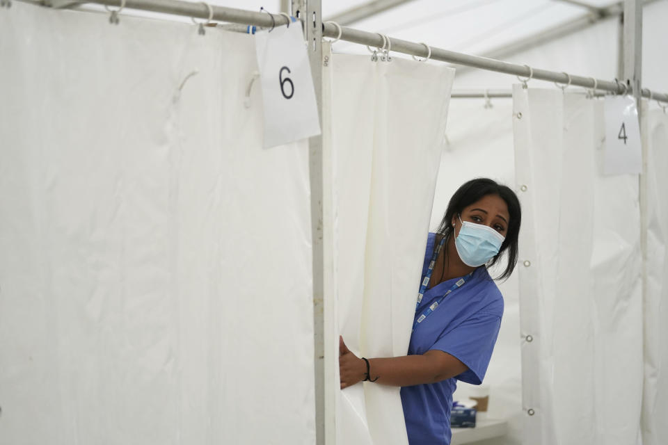 An NHS nurse looks for patients at a pop-up vaccination centre during a four-day Covid-19 vaccine festival in Langdon Park, east London, Saturday July 31, 2021. The authorities are implementing a program of short term pop-up vaccination sites in an attempt to prompt people to get the jab. (Kirsty O'Connor/PA via AP)