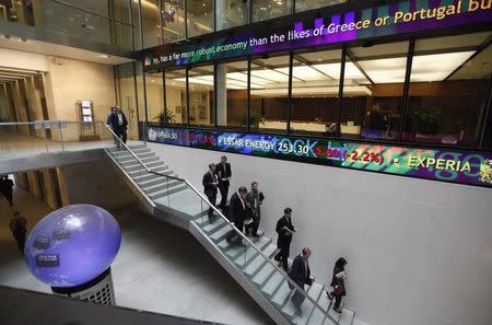 People walk down a stairway inside the London Stock Exchange Atrium in London November 17, 2011. REUTERS/Suzanne Plunkett