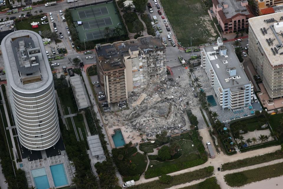 A massive pile of rubble is seen amid other beachfront buildings.