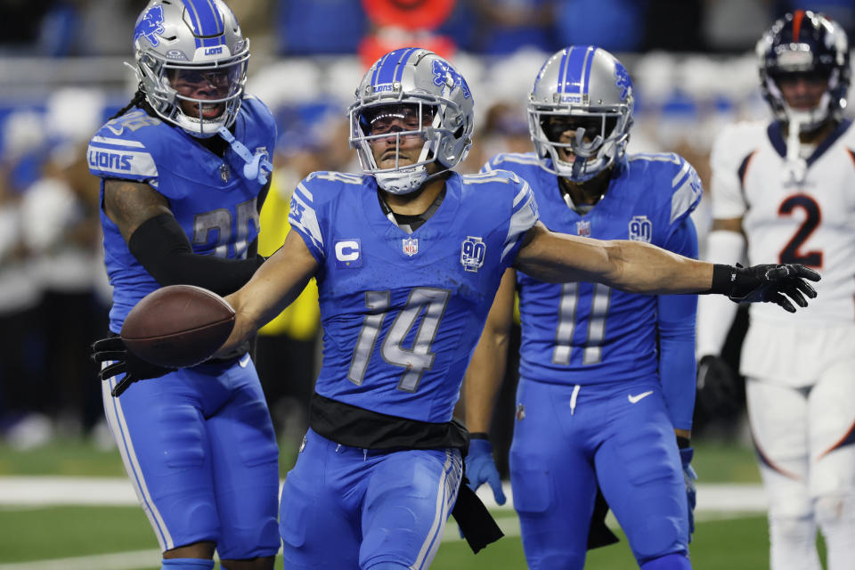 Detroit Lions wide receiver Amon-Ra St. Brown (14) kicks the ball into the stands after his touchdown during the first half of an NFL football game against the Denver Broncos, Saturday, Dec. 16, 2023, in Detroit. (AP Photo/Duane Burleson)