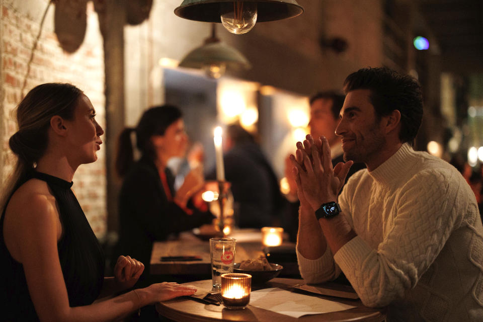 A group of diners have a drink and candle lit dinner at Brasserie Surrealiste in Brussels, Wednesday, Sept. 28, 2022. A group of restaurant owners in Brussels has imagined how a future without gas and electricity would look like for gourmets. Dinner guests, served at the Brasserie Surrealiste and cooked by Racines restaurant employees, were the first to experience it: No ovens, no stoves, no hot plates, no coffee machines and no light bulbs. (AP Photo/Olivier Matthys)