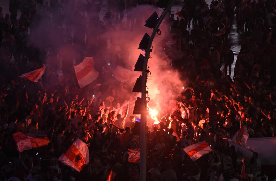 River Plate soccer fans light flares as they celebrate their 3-1 victory over Boca Juniors and clenching the Copa Libertadores championship title, at the Obelisk in Buenos Aires, Argentina, Sunday, Dec. 9, 2018. The South American decider was transferred from Buenos Aires to Madrid, Spain after River fans attacked Boca's bus on Nov. 10 ahead of the second leg. (AP Photo/Gustavo Garello)