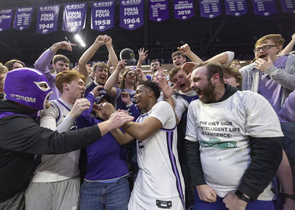 Kansas State's Tylor Perry, middle, celebrates with fans after Perry's 26 points helped knock off Kansas in an NCAA college basketball game, Monday, Feb. 5, 2024, in Manhattan, Kan. (Travis Heying/The Wichita Eagle via AP)