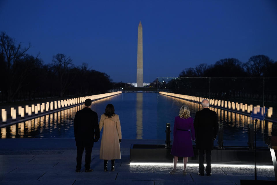 With the Washington Monument in the background, President-elect Joe Biden with his wife Jill Biden and Vice President-elect Kamala Harris with her husband Doug Emhoff listen as Yolanda Adams sings "Hallelujah" during a COVID-19 memorial, with lights placed around the Lincoln Memorial Reflecting Pool, Tuesday, Jan. 19, 2021, in Washington. (AP Photo/Evan Vucci)