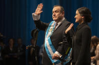 Alejandro Giammattei waves to the crowd accompanied by his daughter Ana Marcela after he was sworn-in as president of Guatemala at the National Theater in Guatemala City, Tuesday, Jan. 14, 2020. Guatemala swears in Giammattei, a conservative physician opposed to gay marriage and abortion, as its new president Tuesday while the country's outgoing leader exits amid swirling corruption accusations. (AP Photo/Moises Castillo)