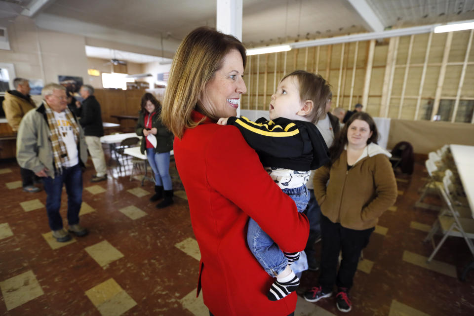 In this Nov. 11, 2019, photo, U.S. Rep. Cindy Axne, D-Iowa, holds a baby after speaking to local residents at the American Legion Post 184 in Winterset, Iowa. Axne defeated a Republican incumbent in 2018 even as she lost 15 of her district's 16 counties. Axne won by offsetting her losses in rural counties with an overwhelming victory in urban Polk County. (AP Photo/Charlie Neibergall)