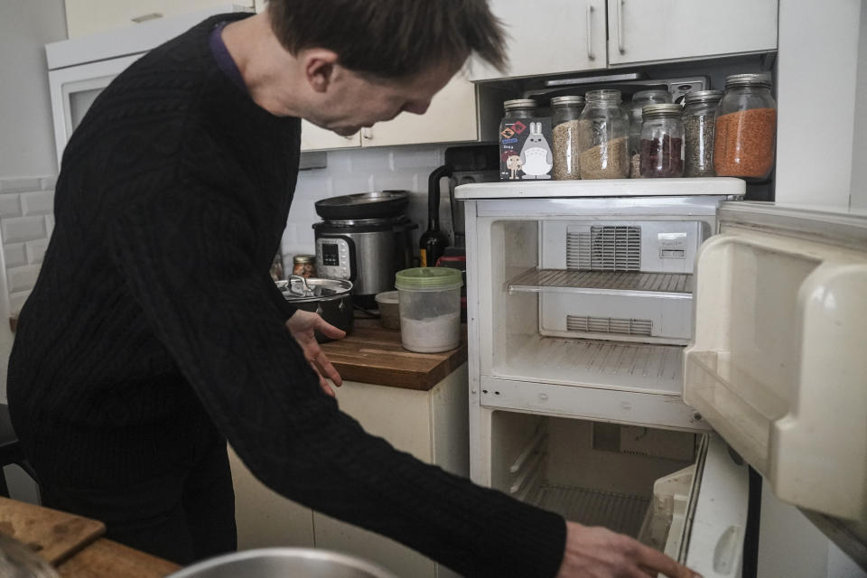 Josh Spodek muestra su refrigerador vacío, luego de haberlo desenchufado hace tiempo como parte de su búsqueda de una vida sostenible, el martes 24 de enero de 2023, en su apartamento en Greenwich Village, Nueva York. Más allá del ahorro de energía, Spodek dice que sin refrigerador ha aprendido a cocinar mejor y a desarrollar técnicas de fermentación utilizando una variedad más amplia de productos de temporada. (AP Foto/Bebeto Matthews)