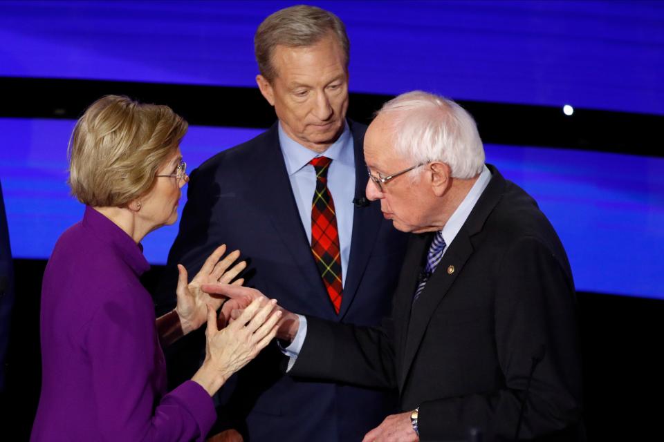 Democratic presidential candidate Sen. Elizabeth Warren, D-Mass., left and Sen. Bernie Sanders, I-Vt., talk Tuesday, Jan. 14, 2020, after a Democratic presidential primary debate hosted by CNN and the Des Moines Register in Des Moines, Iowa. Candidate businessman Tom Steyer looks on.